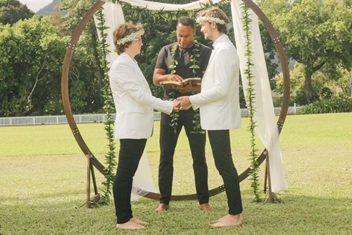 A couple getting married on Kauaʻi in front of a circle arch